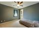 Cozy bedroom with a ceiling fan, window with curtains, and neutral-toned walls at 20552 W Carlton Mnr, Buckeye, AZ 85396