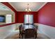 Formal dining room showcasing ornate table/chairs, statement lighting, and bold red accent wall at 20552 W Carlton Mnr, Buckeye, AZ 85396