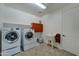 Functional laundry room with modern washer/dryer, utility sink, and built-in storage cabinets at 20552 W Carlton Mnr, Buckeye, AZ 85396