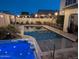 Backyard pool with an attached jacuzzi surrounded by charming string lights at night at 20552 W Carlton Mnr, Buckeye, AZ 85396