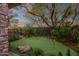 Putting green in a lush backyard setting with mature trees and stone accents at 21893 N 78Th St, Scottsdale, AZ 85255