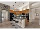 Modern kitchen with island, breakfast bar, and stone accent wall at 21893 N 78Th St, Scottsdale, AZ 85255