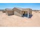 Home's backyard with an extended covered patio, and desert landscape surrounding the property at 21916 W Duane Ln, Wittmann, AZ 85361