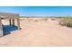 Large backyard space with desert landscaping and a covered patio at 21916 W Duane Ln, Wittmann, AZ 85361