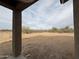 Spacious backyard showing native desert vegetation as viewed from a covered patio area at 21916 W Duane Ln, Wittmann, AZ 85361