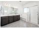 Bright bathroom features dual sinks, sleek vanity, separate tub, and glass-enclosed shower for spa-like experience at 21916 W Duane Ln, Wittmann, AZ 85361