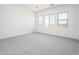 Bright bedroom featuring neutral carpet, white walls, and multiple windows offering natural light at 21916 W Duane Ln, Wittmann, AZ 85361