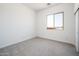 Bedroom with a closet, neutral carpet, and a large window that offers a bright view to the exterior at 21916 W Duane Ln, Wittmann, AZ 85361