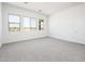 Inviting bedroom boasts neutral carpet, white walls, and plenty of natural light from three large windows at 21916 W Duane Ln, Wittmann, AZ 85361