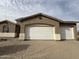 Exterior view of the garage with white doors and tan stucco finish, complementing the home's architecture at 21916 W Duane Ln, Wittmann, AZ 85361