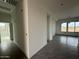 Bright hallway featuring modern gray tile flooring, fresh white walls, and natural light, leading to other rooms at 21916 W Duane Ln, Wittmann, AZ 85361