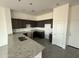 Modern kitchen featuring dark cabinets, granite countertops, stainless steel sink, and gray tile flooring at 21916 W Duane Ln, Wittmann, AZ 85361