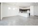Open living space with grey tiled floors, a view of the kitchen and bright natural light at 21916 W Duane Ln, Wittmann, AZ 85361
