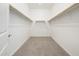 Walk-in closet with neutral carpet and wooden rods providing ample storage space at 21916 W Duane Ln, Wittmann, AZ 85361