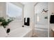 Bathroom with soaking tub, window, and neutral color scheme at 2441 W Beverly Rd, Phoenix, AZ 85041