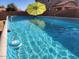 Refreshing pool with a bright yellow umbrella and clear blue water in a fenced backyard at 2441 W Beverly Rd, Phoenix, AZ 85041