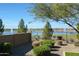 Landscaped backyard with lake view, fountain, and shrubs at 24454 N 173Rd Ln, Surprise, AZ 85387