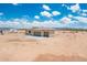 A single-story home with neutral tones and a spacious three-car garage nestled in a desert landscape at 25519 W Brookhart Way, Wittmann, AZ 85361