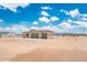 A single-story home with neutral tones and a spacious three-car garage nestled in a desert landscape at 25519 W Brookhart Way, Wittmann, AZ 85361