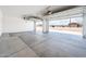 Clean garage interior with concrete floor and automatic door, offering space and functionality at 25519 W Brookhart Way, Wittmann, AZ 85361