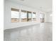 Bright and spacious living room with neutral tones, light gray flooring, and large windows at 25519 W Brookhart Way, Wittmann, AZ 85361