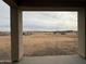 Framed view from the covered patio, showcasing the expansive vacant lot and horizon at 25519 W Brookhart Way, Wittmann, AZ 85361