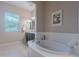 Bathroom with a luxurious soaking tub and large window at 2952 E Warbler Rd, Gilbert, AZ 85297