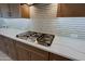 Modern gas cooktop and white quartz countertops in the kitchen at 3020 N 165Th Ave, Goodyear, AZ 85395