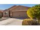 Tan house with brown garage door, landscaping, and paved driveway at 30358 N Juniper Dr, Florence, AZ 85132