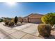 Houses with tan exterior and brown garage doors, landscaping, and paved driveways at 30358 N Juniper Dr, Florence, AZ 85132