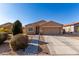 Tan house with brown garage door, landscaping, and paved driveway at 30358 N Juniper Dr, Florence, AZ 85132