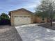 Tan two-car garage with a gravel driveway and desert landscaping at 31655 N 131St Ave, Peoria, AZ 85383