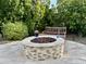 Stone fire pit with bench seating in backyard at 31655 N 131St Ave, Peoria, AZ 85383