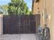 Wooden gate leading to the backyard with desert landscaping and utility hookups at 31655 N 131St Ave, Peoria, AZ 85383