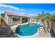 Aerial view of the home's backyard showing swimming pool, rock waterfall, lush landscape and covered patio at 3383 E Santa Fe Ln, Gilbert, AZ 85297