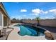 Relaxing kidney-shaped pool surrounded by a stone patio and palm trees at 3383 E Santa Fe Ln, Gilbert, AZ 85297