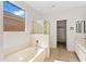 Bright bathroom featuring a soaking tub, glass shower, and tile flooring for a spa-like experience at 3383 E Santa Fe Ln, Gilbert, AZ 85297