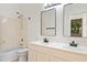 Well-lit bathroom with dual sinks, black fixtures, and a shower-tub combination at 3383 E Santa Fe Ln, Gilbert, AZ 85297