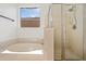 Bright bathroom featuring a soaking tub, glass shower, and tile flooring for a spa-like experience at 3383 E Santa Fe Ln, Gilbert, AZ 85297