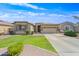 Tan single-story home with a well-manicured lawn, stone accents, and a two-car garage at 3383 E Santa Fe Ln, Gilbert, AZ 85297