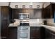 Kitchen with dark wood cabinets, granite counters, and stainless steel appliances at 3383 E Santa Fe Ln, Gilbert, AZ 85297