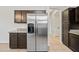 Kitchen with stainless steel refrigerator, granite countertops, dark cabinets, and tile flooring at 3383 E Santa Fe Ln, Gilbert, AZ 85297
