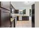 Galley style kitchen boasts granite countertops, dark cabinets, stainless steel appliances and tile flooring at 3383 E Santa Fe Ln, Gilbert, AZ 85297