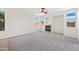 Bright living room with carpet, fireplace, ceiling fan, and multiple windows offering outdoor views at 3383 E Santa Fe Ln, Gilbert, AZ 85297