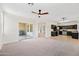 Spacious living room with sliding glass door to covered patio and view of kitchen with dark cabinetry at 3383 E Santa Fe Ln, Gilbert, AZ 85297