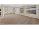 Bright living room featuring carpet, a mirrored accent wall, and views of the pool area through large windows at 3383 E Santa Fe Ln, Gilbert, AZ 85297