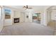 Comfortable living room with a fireplace, ceiling fan, and sliding glass doors that lead to an outdoor area at 3383 E Santa Fe Ln, Gilbert, AZ 85297