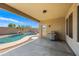 Covered outdoor patio with built-in grill overlooking swimming pool, rock waterfall and lush landscaping at 3383 E Santa Fe Ln, Gilbert, AZ 85297