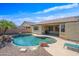 Inviting backyard pool with rock accents, patio, and desert landscaping offers a private outdoor oasis at 3383 E Santa Fe Ln, Gilbert, AZ 85297