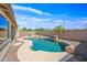Swimming pool features rock waterfall and desert landscaping, creating a tranquil backyard oasis at 3383 E Santa Fe Ln, Gilbert, AZ 85297